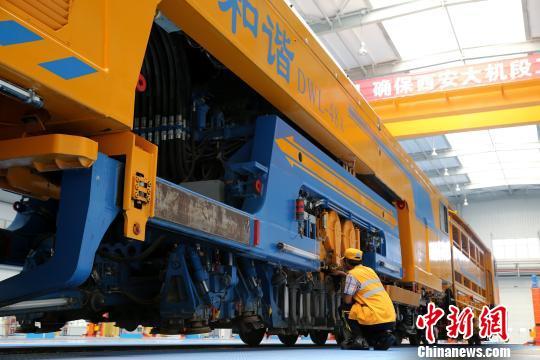 圖為工人正在清理大型養(yǎng)路機械。　張遠 攝